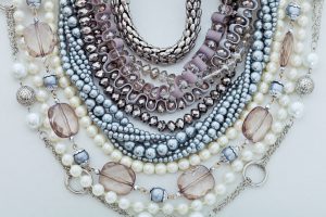 Assortment of different necklaces silver jewelry and pearls.