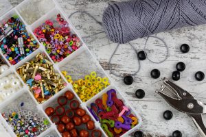 Box with accessories for handcrafts and needlework, in a wood background